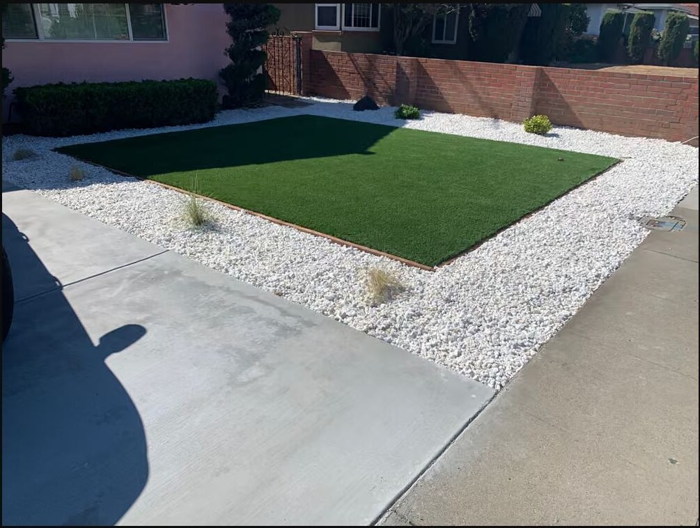 Artificial turf installation with white gravel and planting