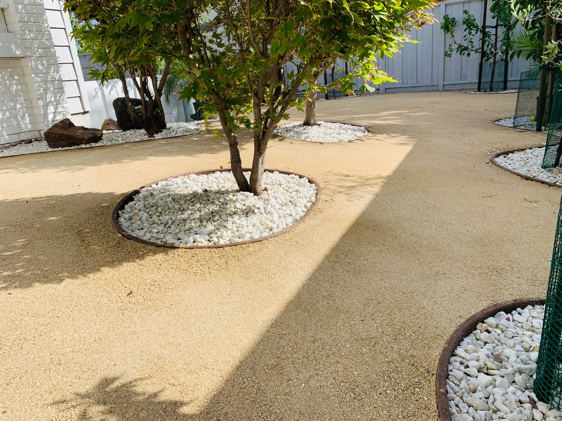 Drought-tolerant landscape installation with decorative stone completed by Garescape in Milpitas, California
