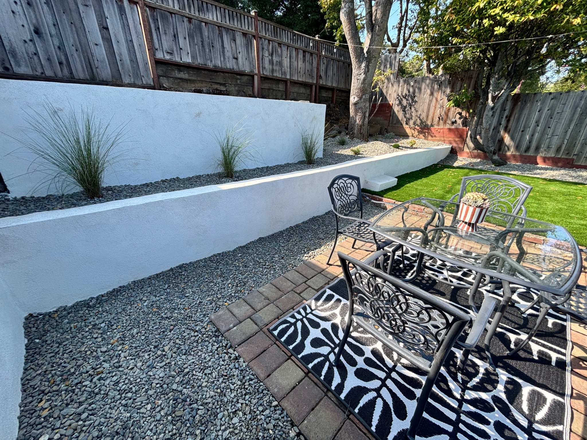 Modern white stucco retaining wall with landscape gravel in San Carlos, California