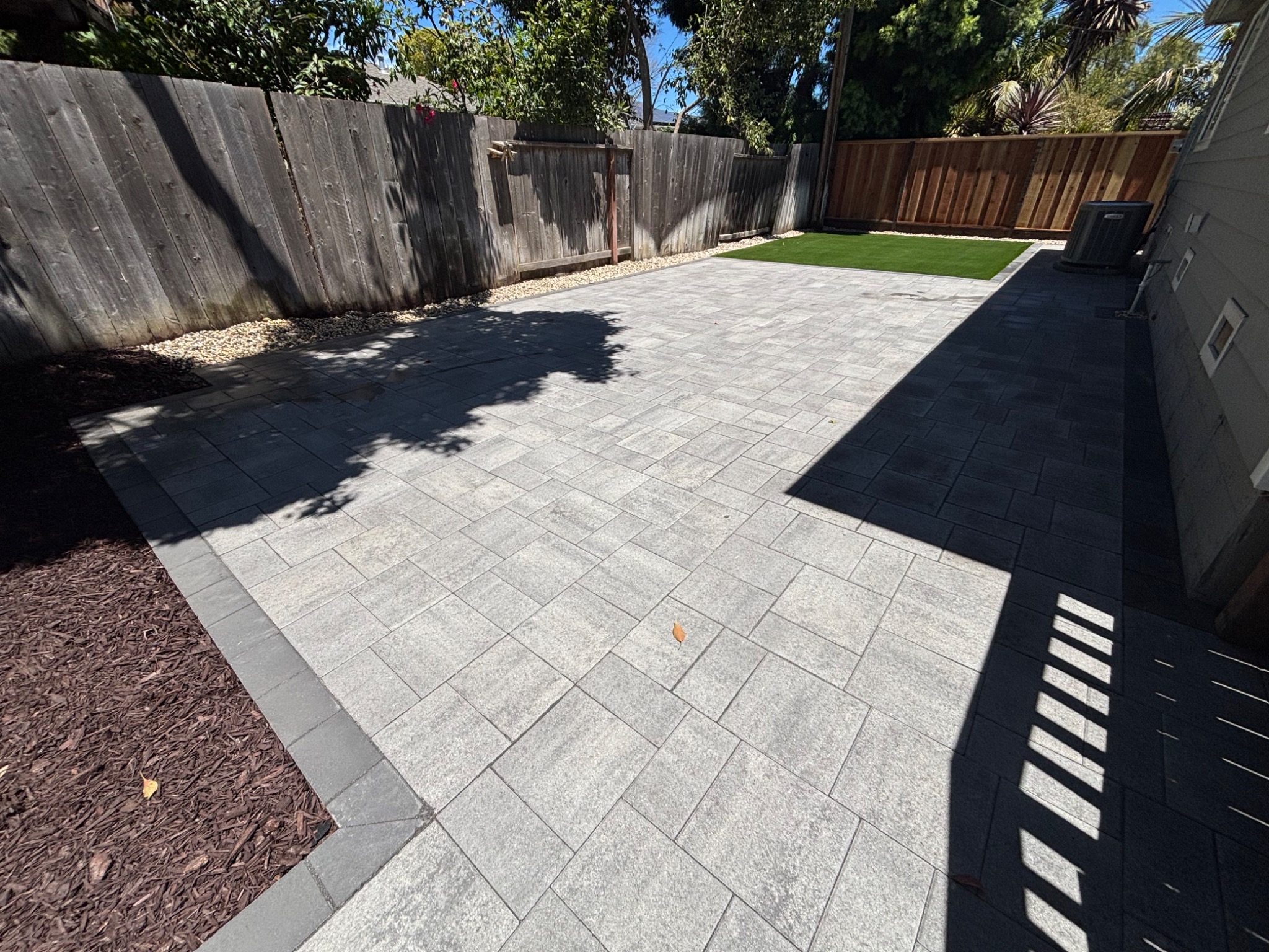 Modern paver patio installation with artificial turf in San Mateo, California