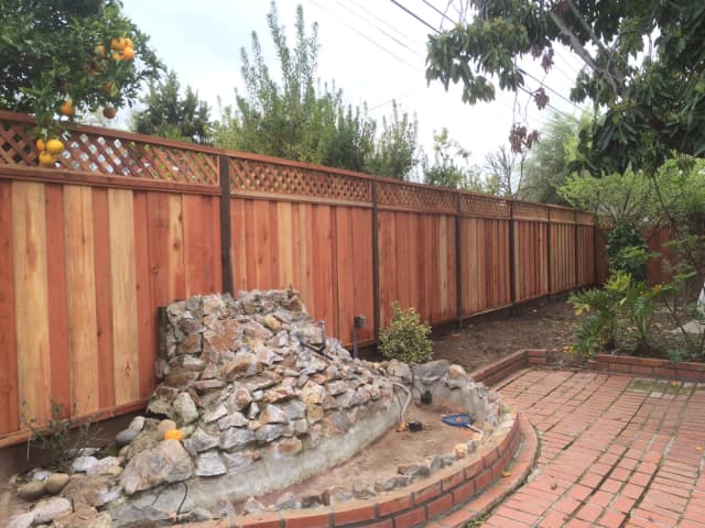 Wood fence with lattice and integrated landscape feature